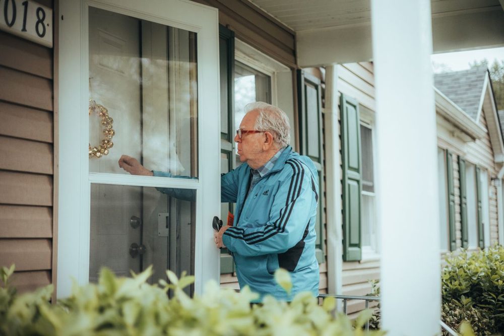 Neighbor checking in on an older resident at their front door