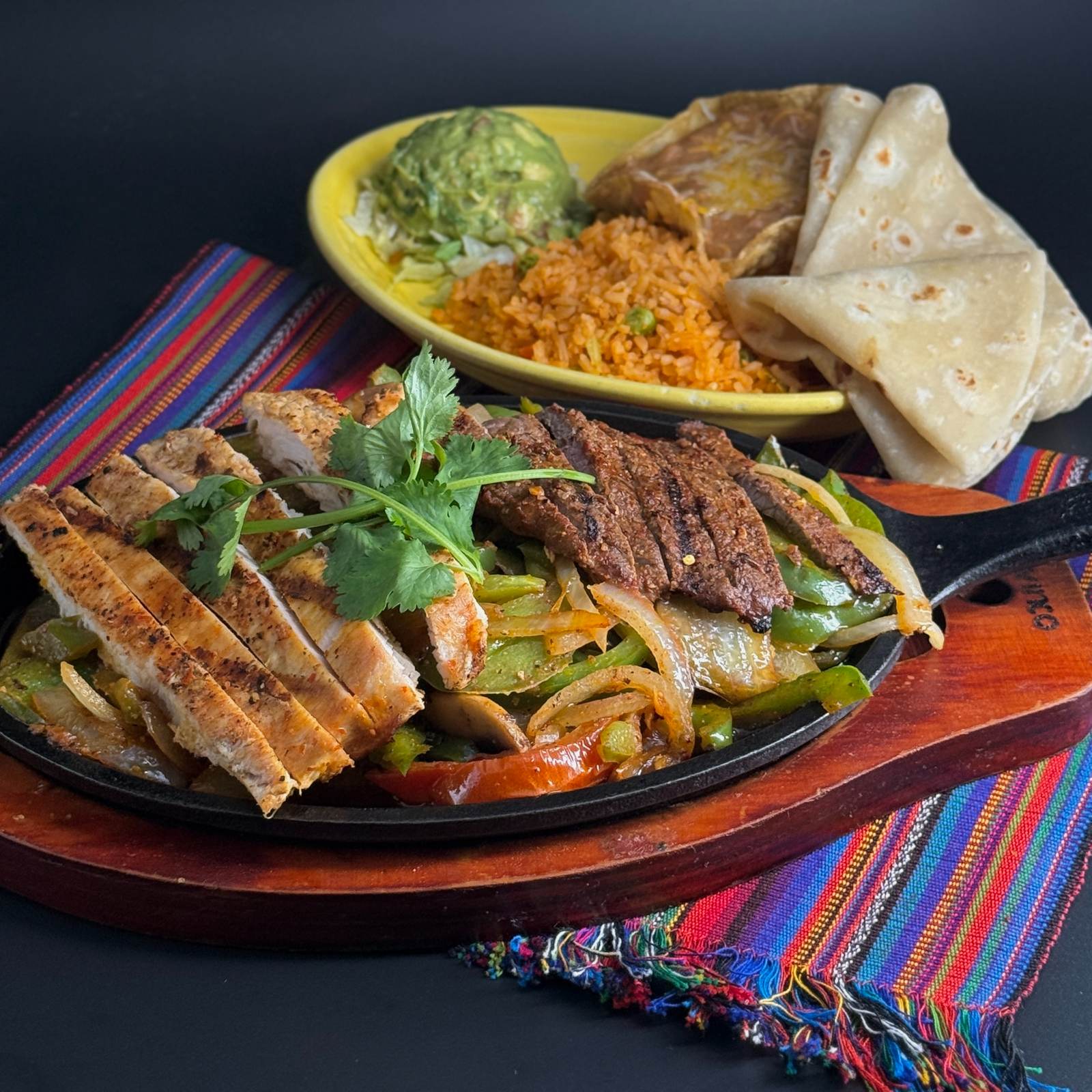 Combination fajitas sizzling with peppers and onions, with guacamole, rice and flour tortillas, at Casa de Bandini, Carlsbad