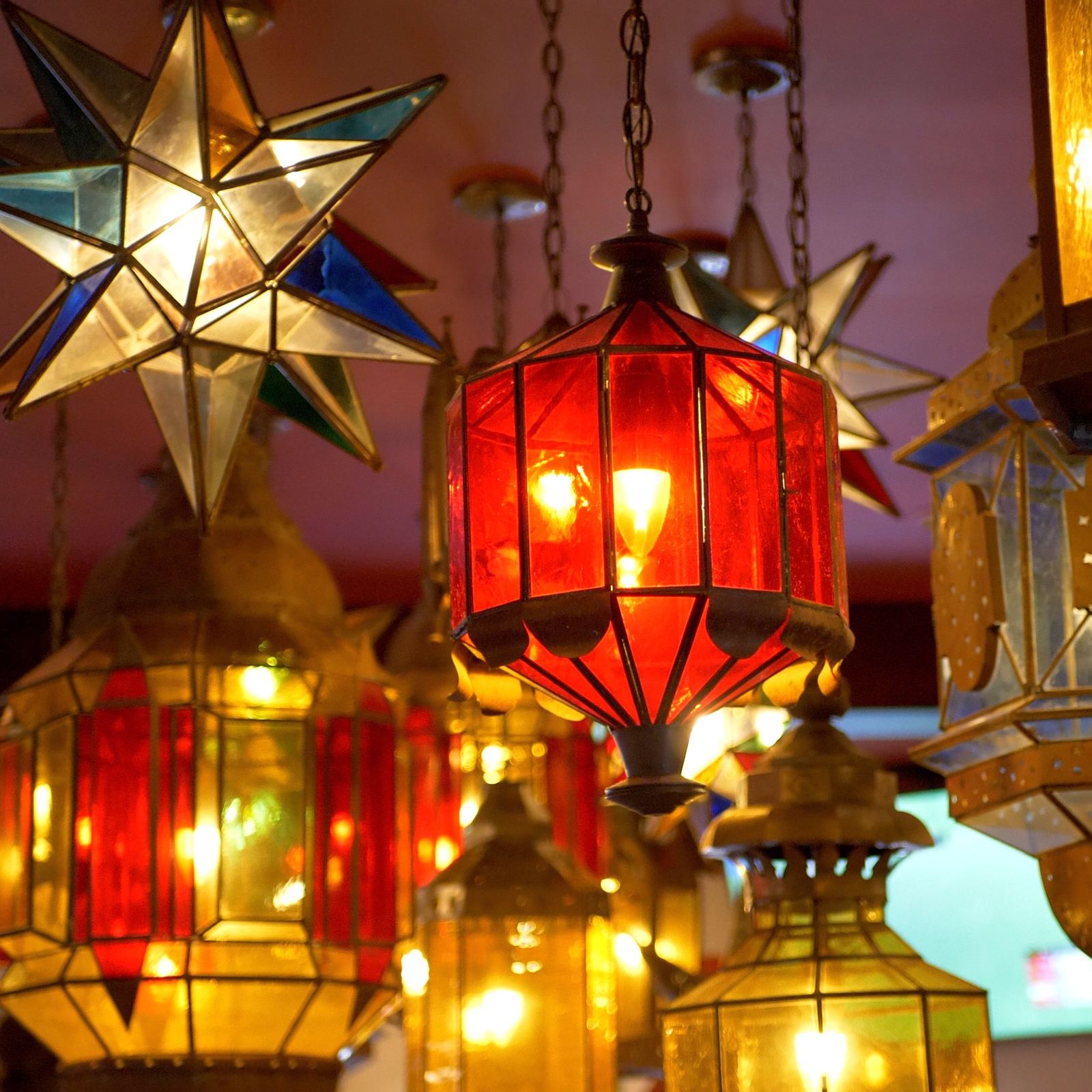 Close view of a tin star lantern and a red glass lantern at Casa de Bandini, Carlsbad