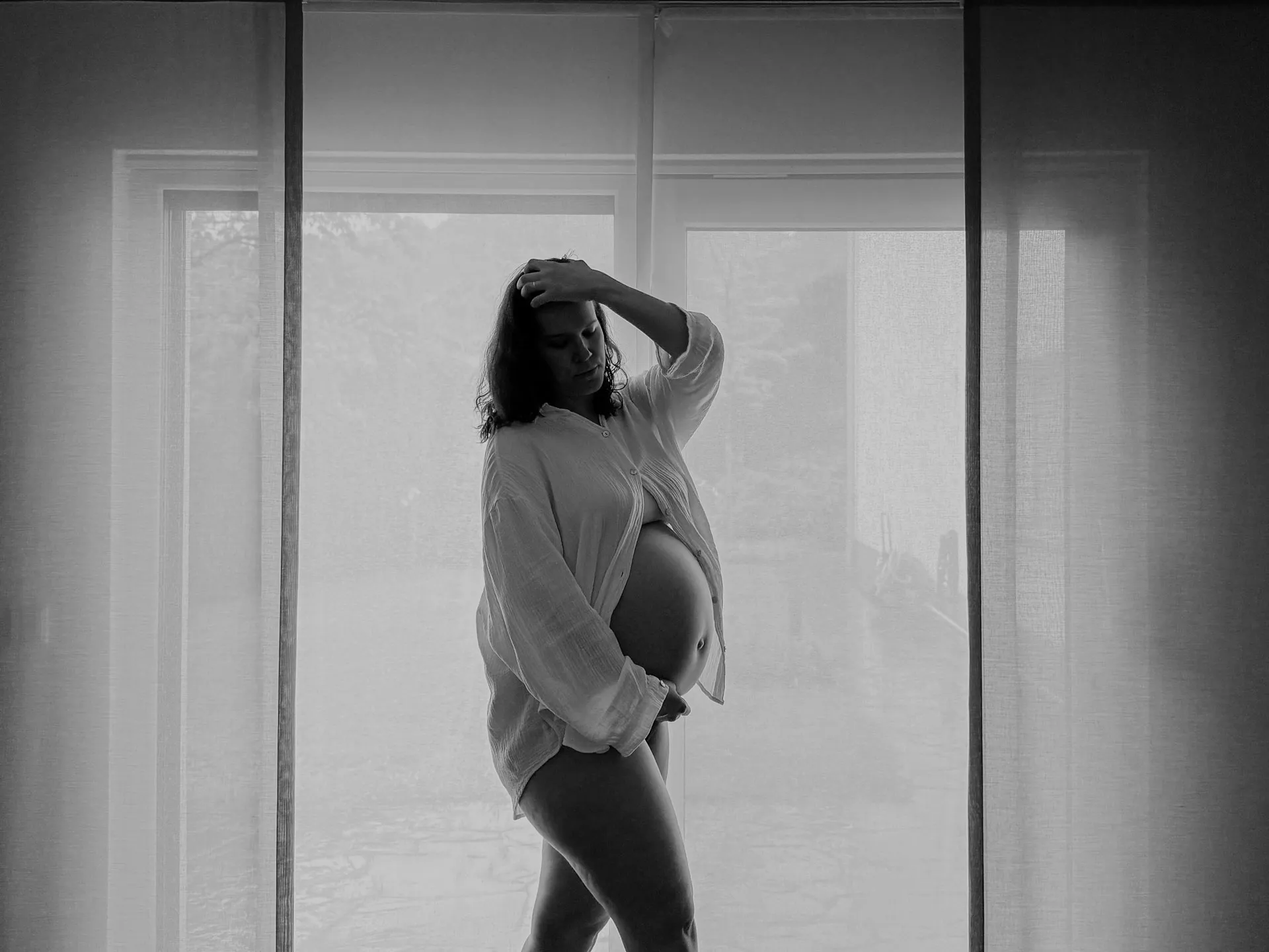 Babybauch-Selbstporträt-Kurs — Schwangere hält das Smartphone für ein Foto in die Höhe