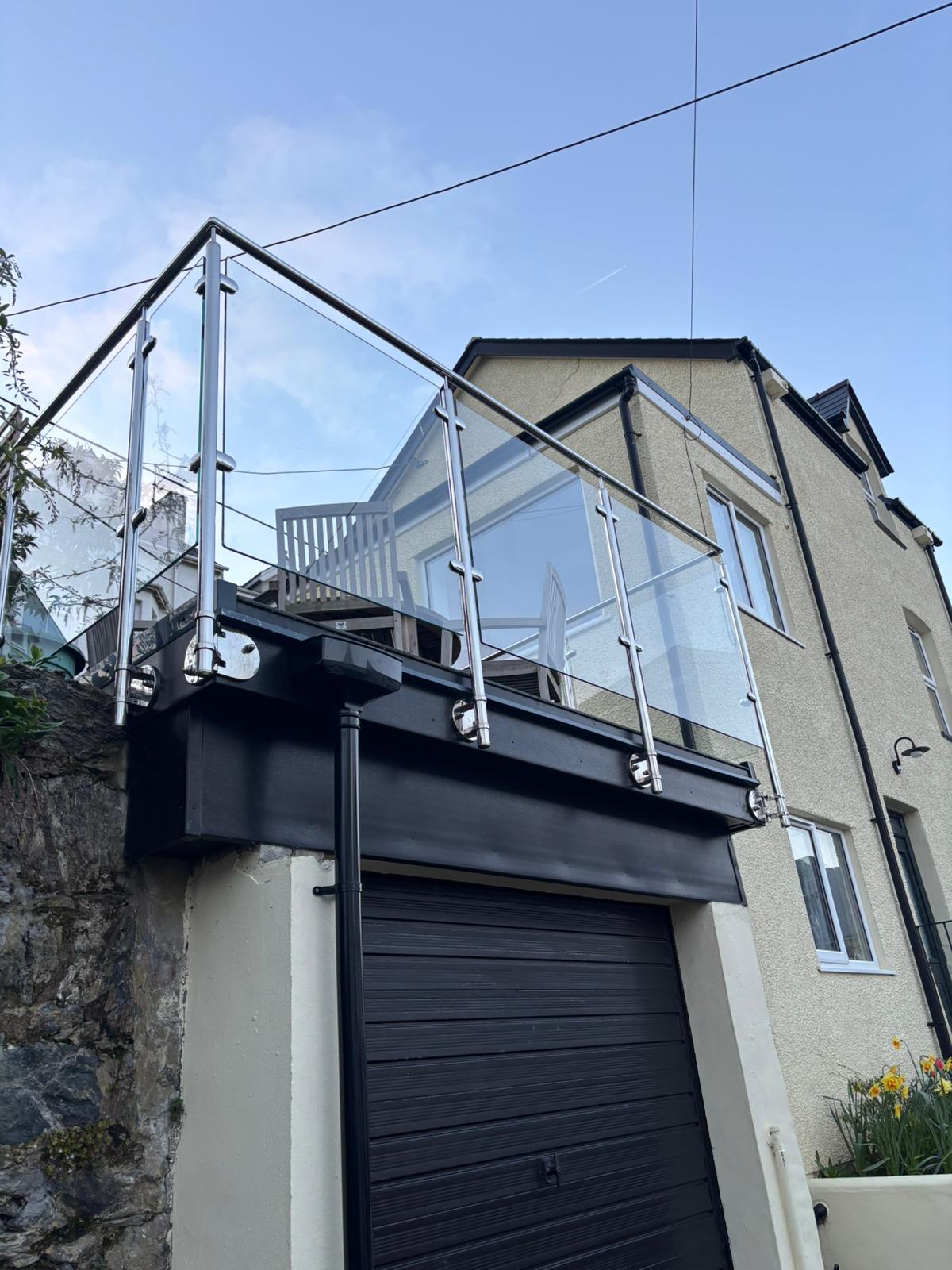 Stainless steel and glass balcony balustrade installed on elevated terrace in Anglesey property