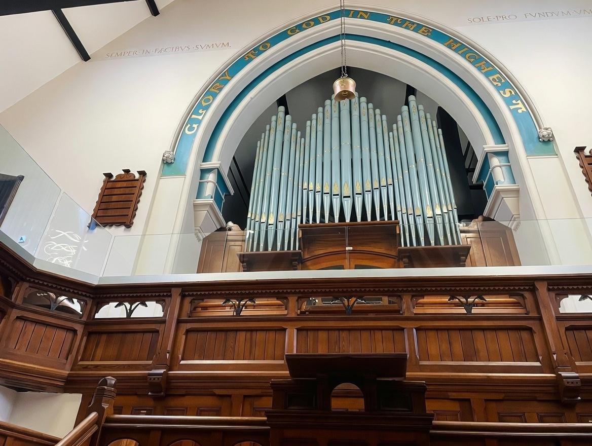 Frameless glass balustrade installed in church conversion preserving original organ and interior features