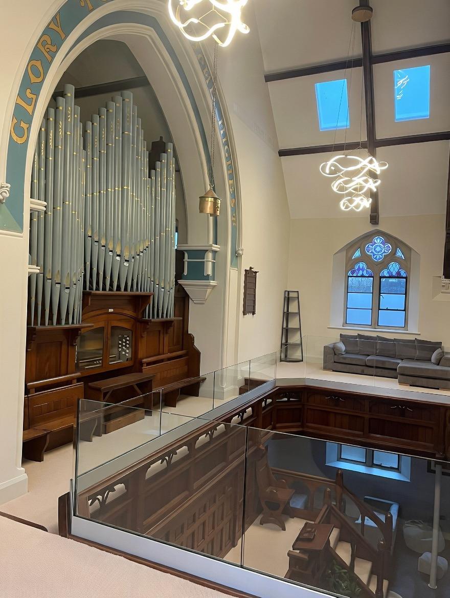 Glass balustrade on internal mezzanine level in converted church with uninterrupted views