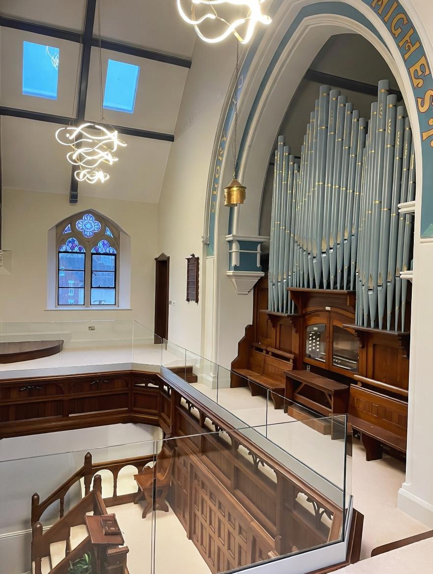 Frameless glass balustrade installation inside converted church building with mezzanine balcony