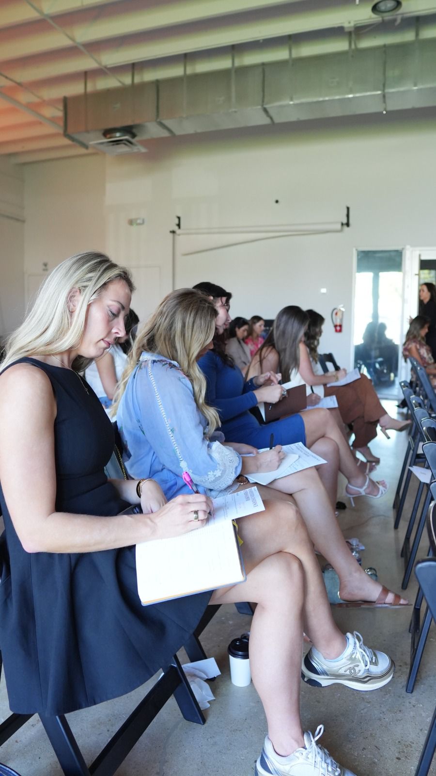 Women taking notes at Liz Kennedy transformation seminar