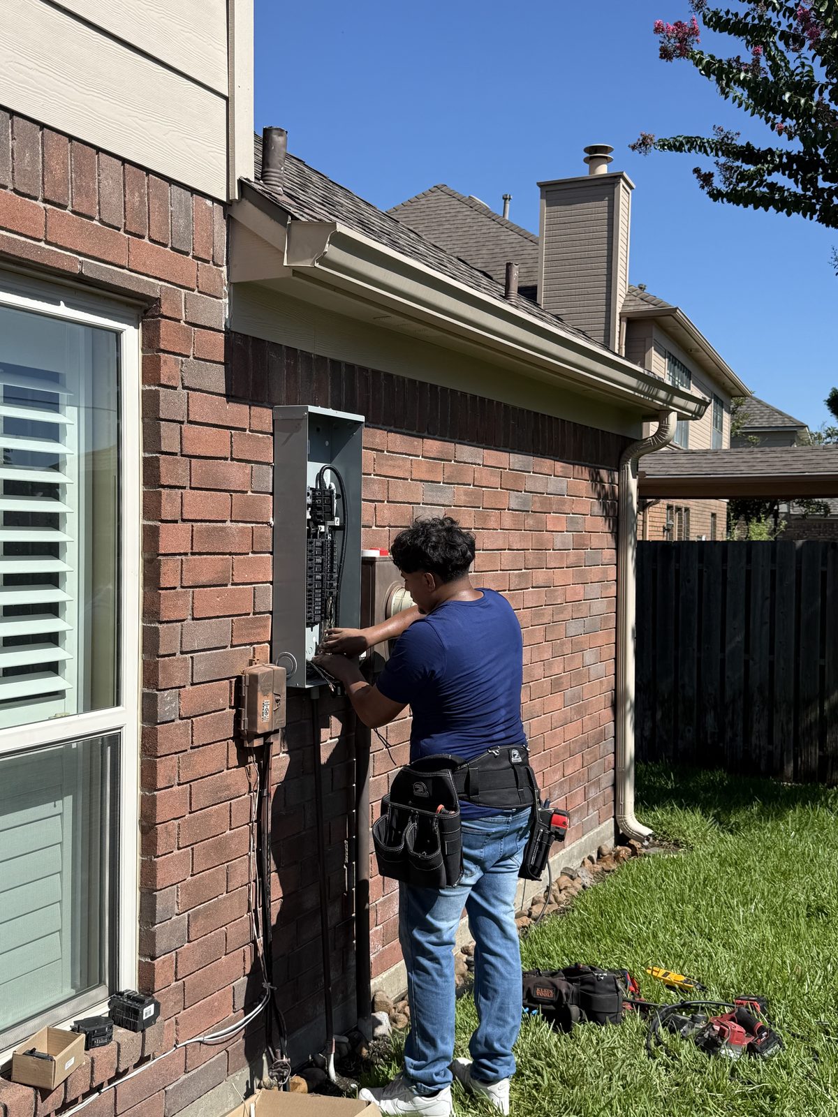 RBG Services electrician replacing an outdoor service panel on a Houston home
