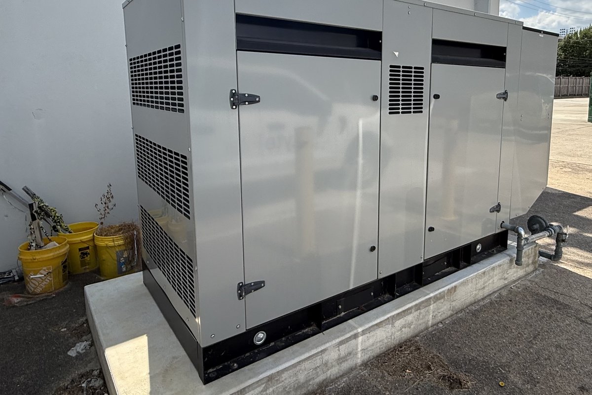Side view of a commercial Gillette generator showing the gas piping and enclosure louvers