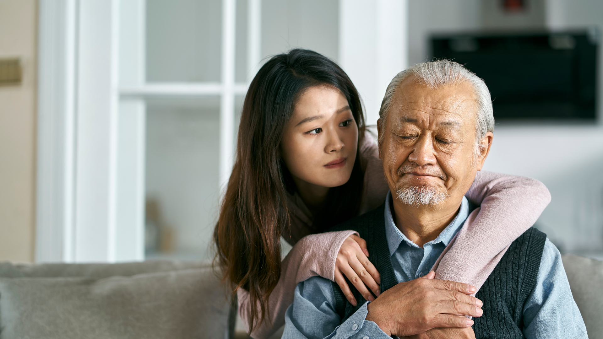 Adult daughter comforting her elderly father at home, showing emotional support, family caregiving, and senior mental health care. Adult daughter comforting her elderly father at home, showing emotional support, family caregiving, and senior mental health care.