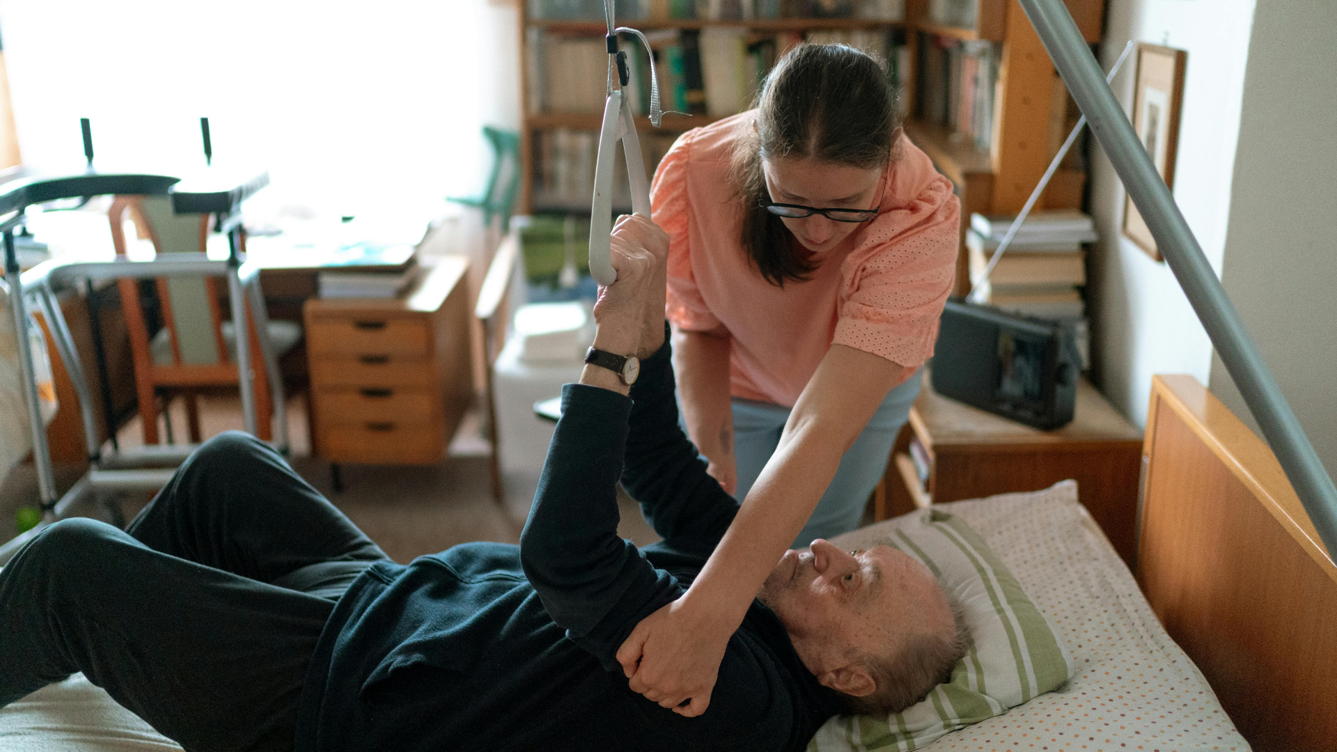 Care Worker helping elderly man out of bed Care Worker helping elderly man out of bed