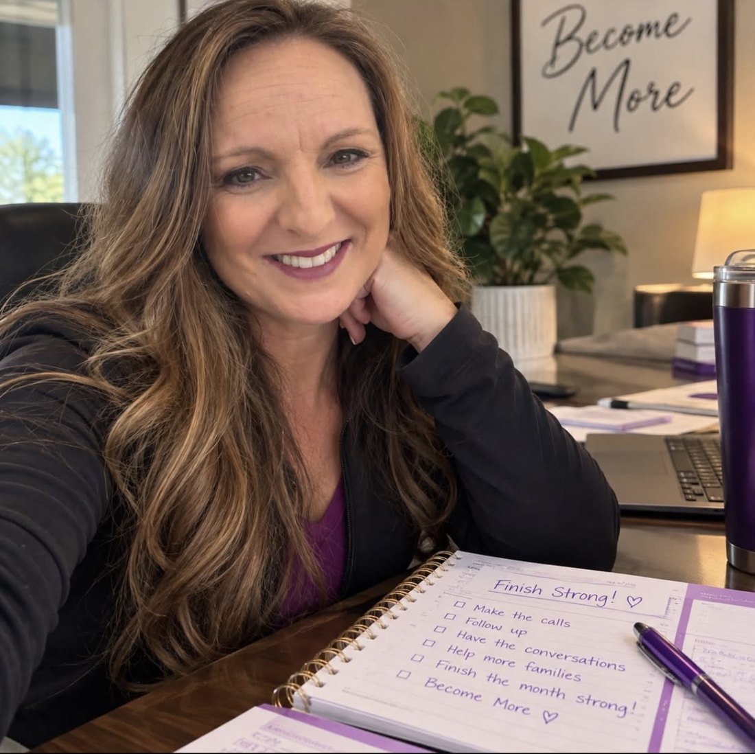 Aprel Landen at her desk beneath a Become More sign