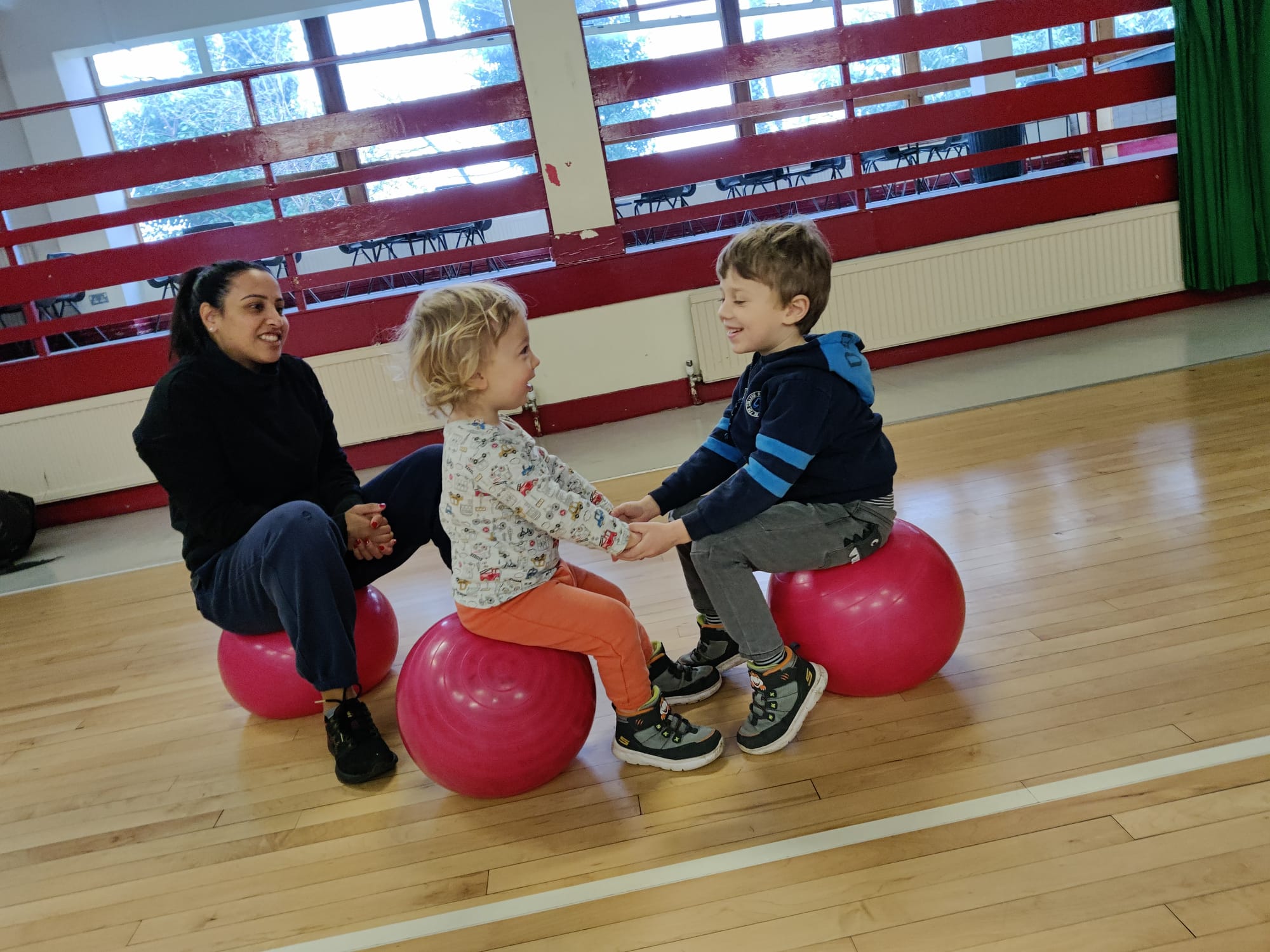 Mad4Sports coach leading children in a ball game at a North London class