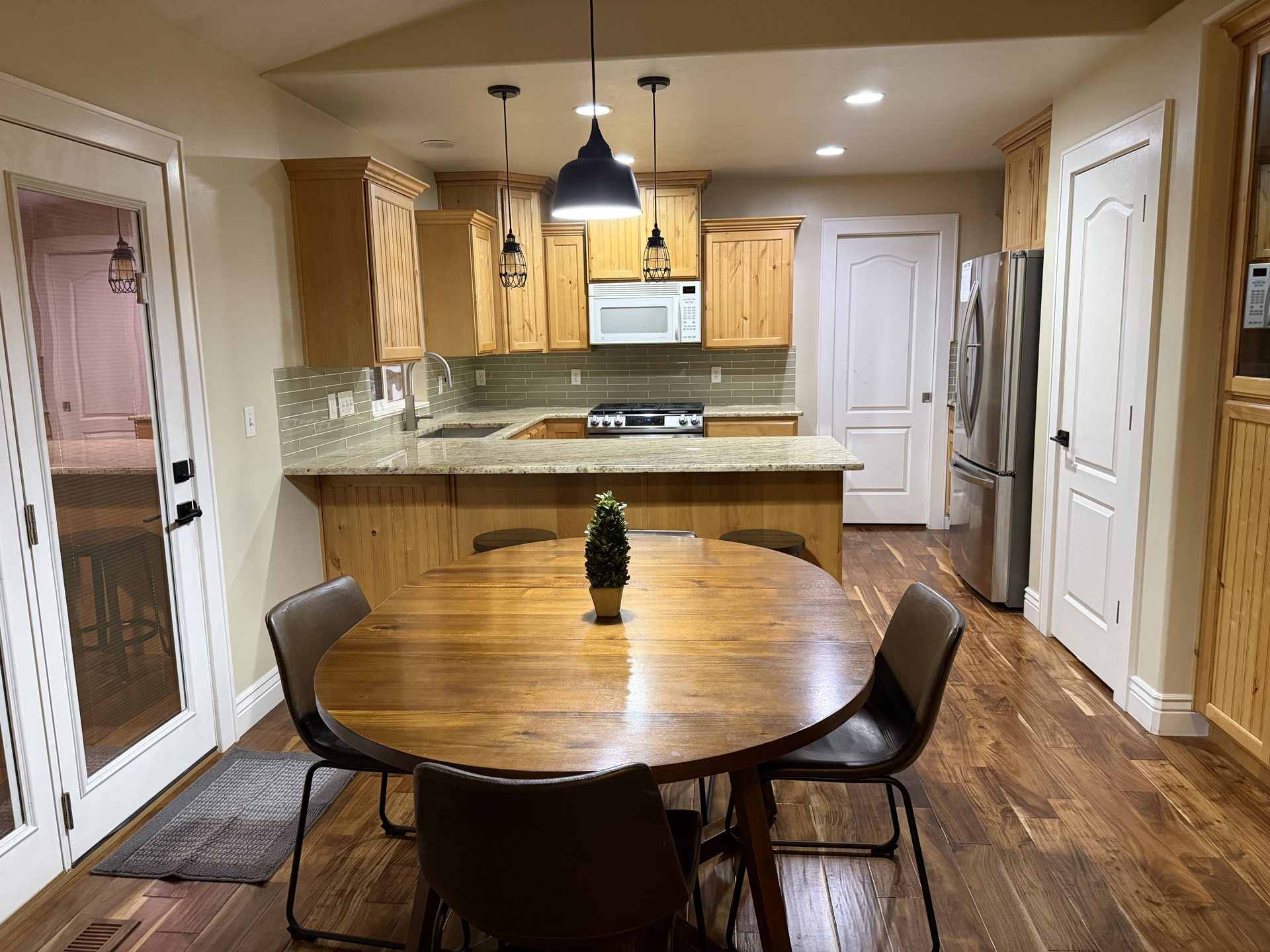 Kitchen and dining with hardwood floors and stainless refrigerator