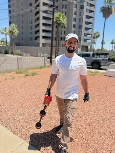 Konnor walking a job site mid-inspection with his red inspection tool