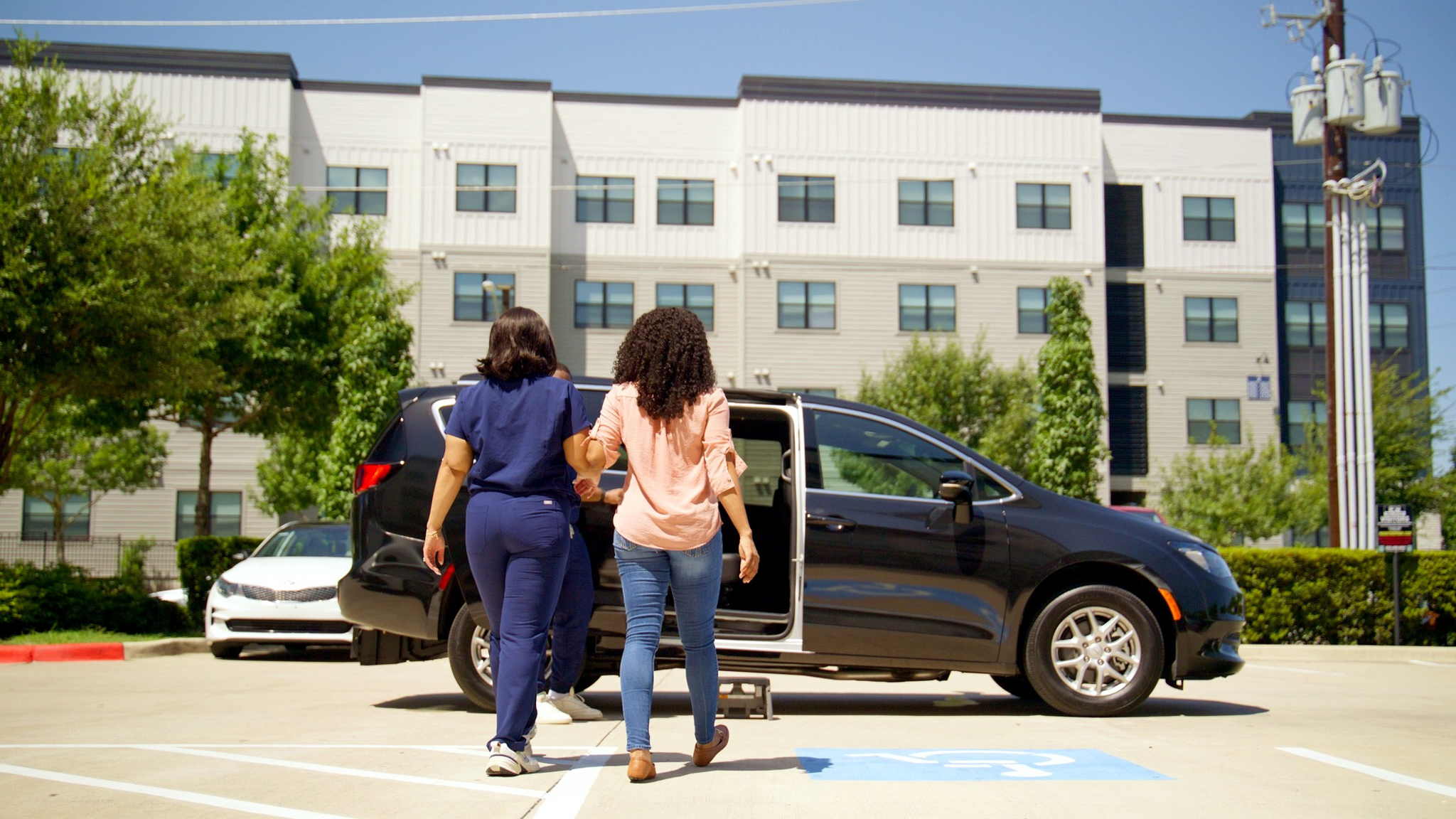 A passenger receiving assistance beside an ElevenO3 vehicle