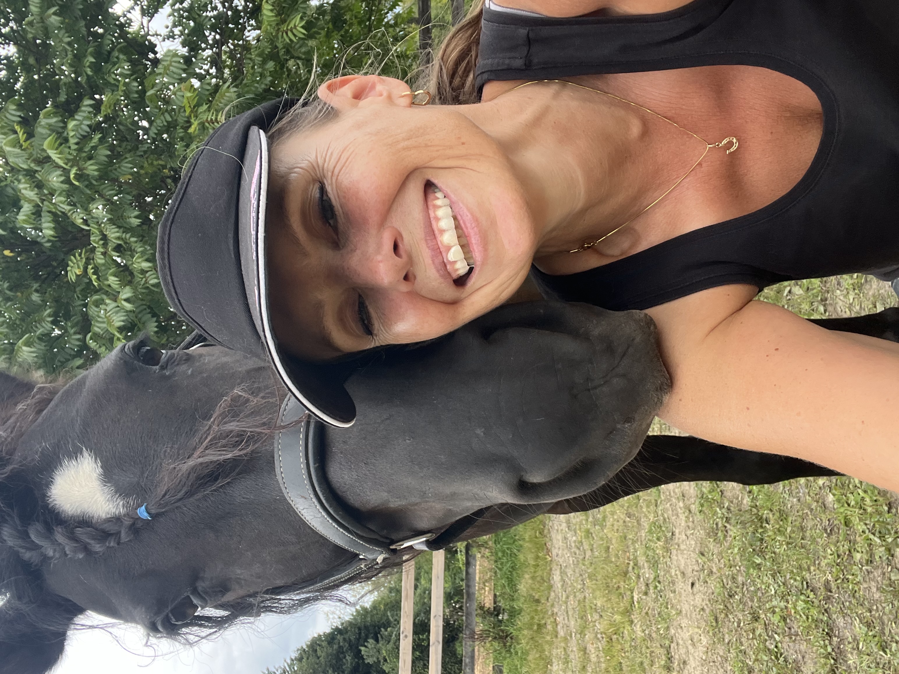 Bara Jones smiling beside her horse