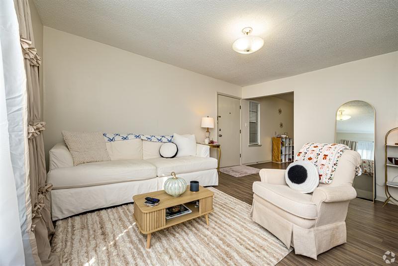 Furnished two-bedroom living room with white sofas