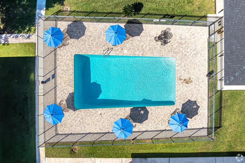 Overhead view of the pool and sundeck with blue umbrellas