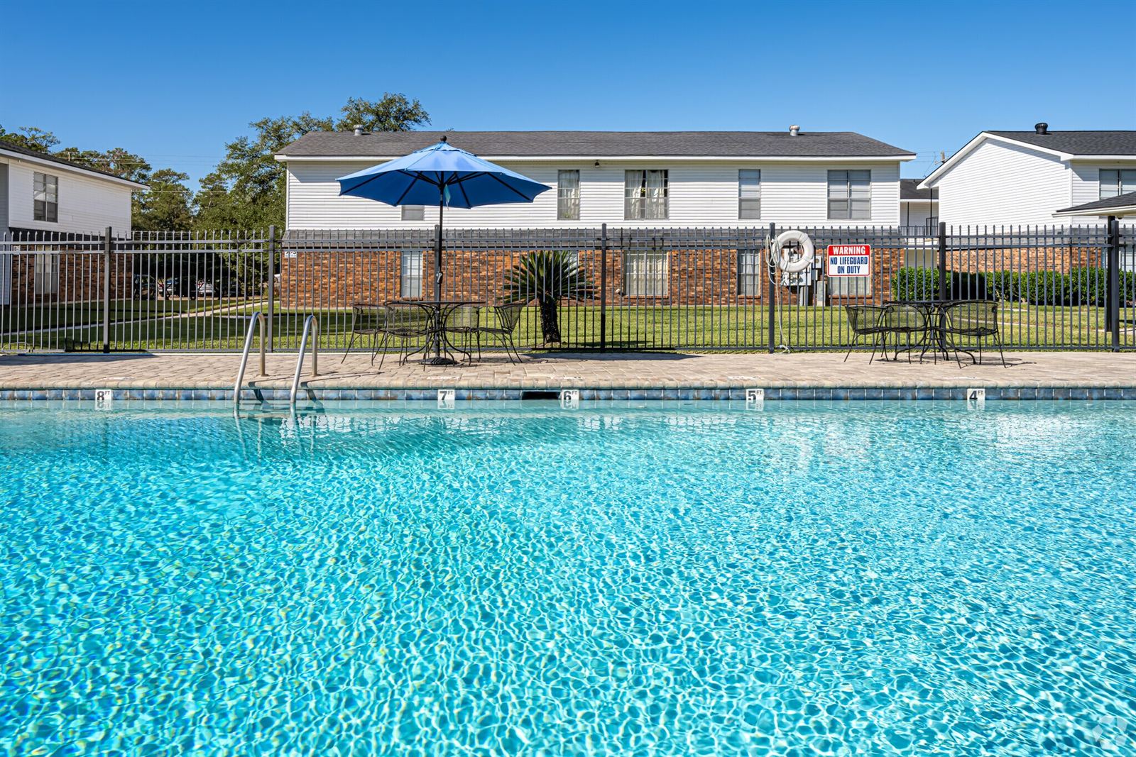 Sparkling pool water with buildings and umbrellas behind