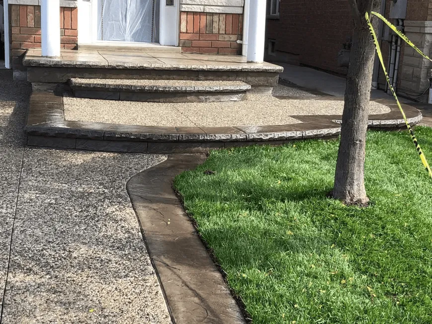 Exposed aggregate porch, steps and walkway beside a front lawn