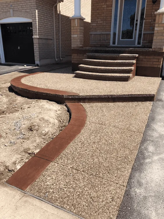 Curved exposed aggregate entrance steps with reddish-brown borders