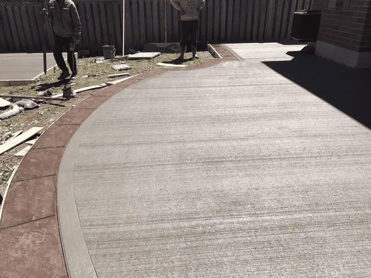 Curved plain concrete walkway through a residential yard