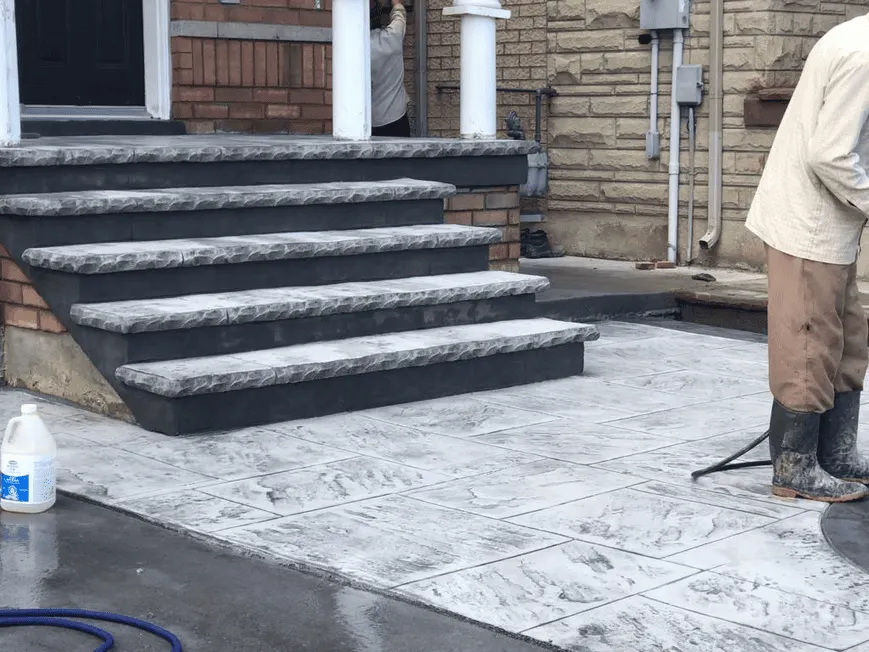 Light stamped concrete front landing with a stone pattern