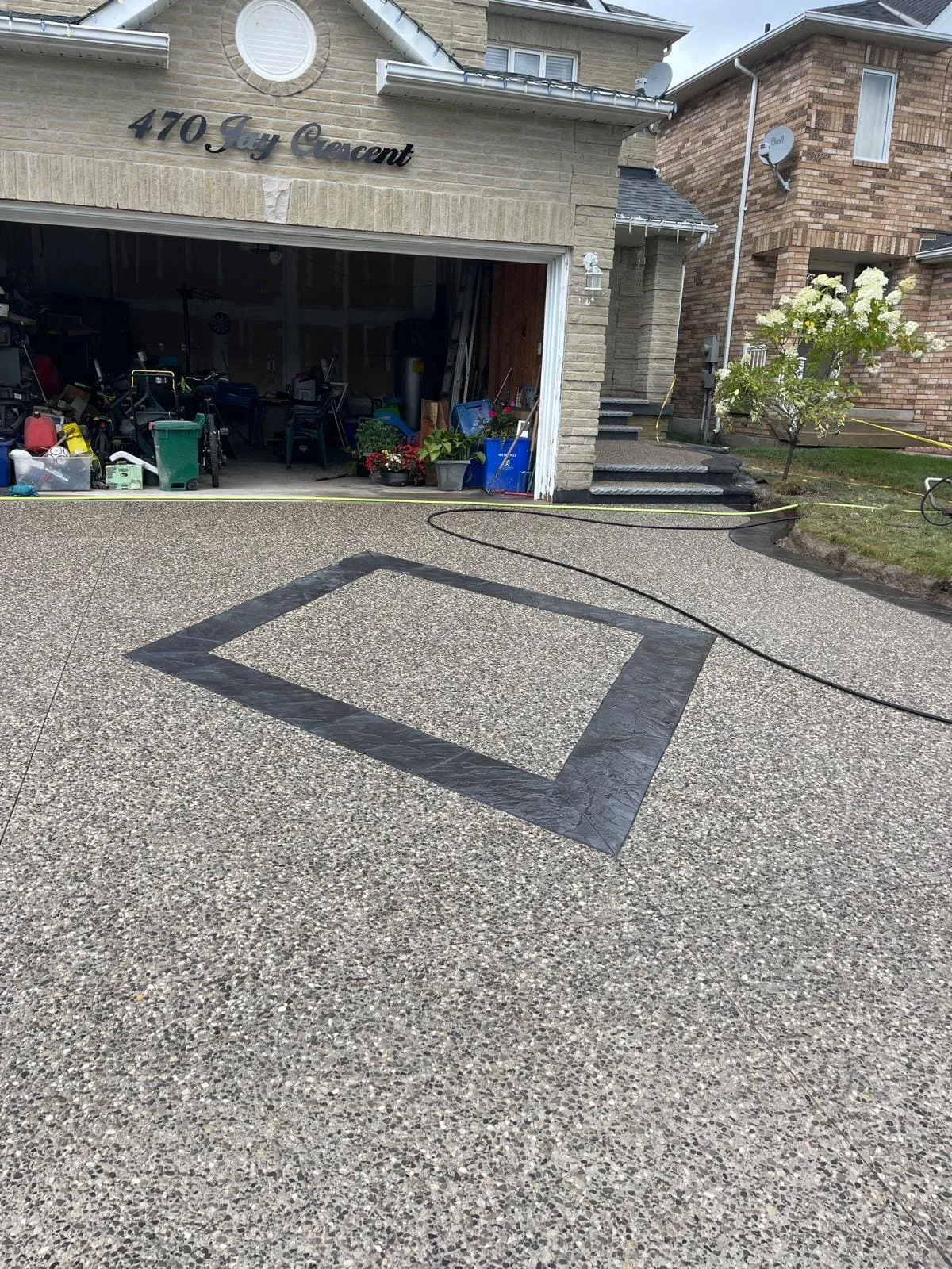 Exposed aggregate driveway with a dark geometric border