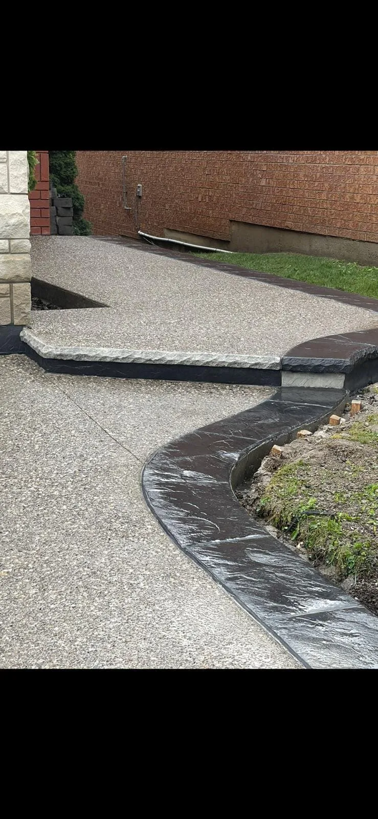 Tall view of an exposed aggregate front walkway and entrance