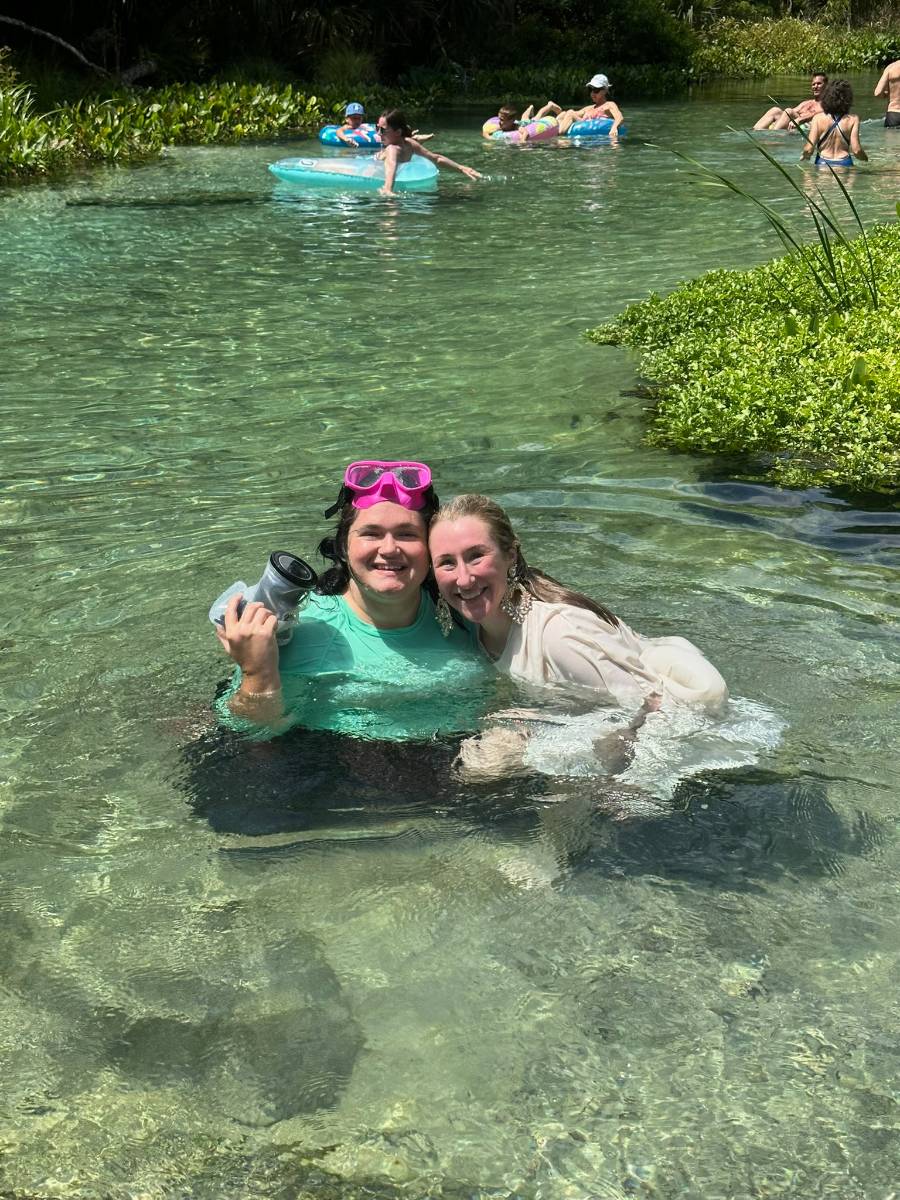 Beatrice and a client smiling together in clear spring water