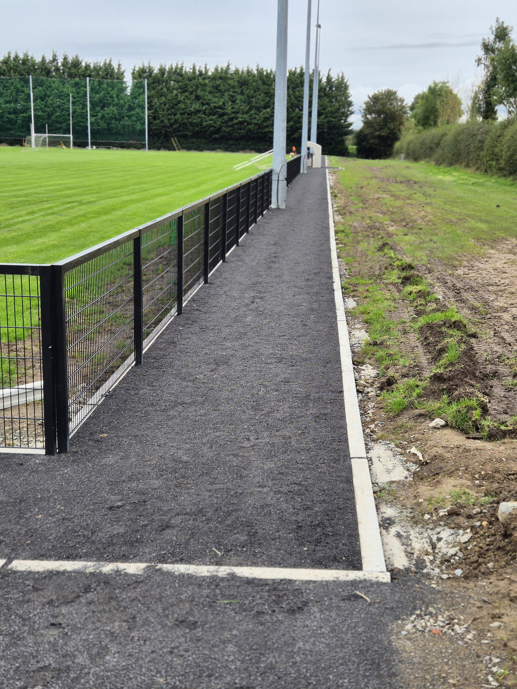 Finished path and fence beside the pitch