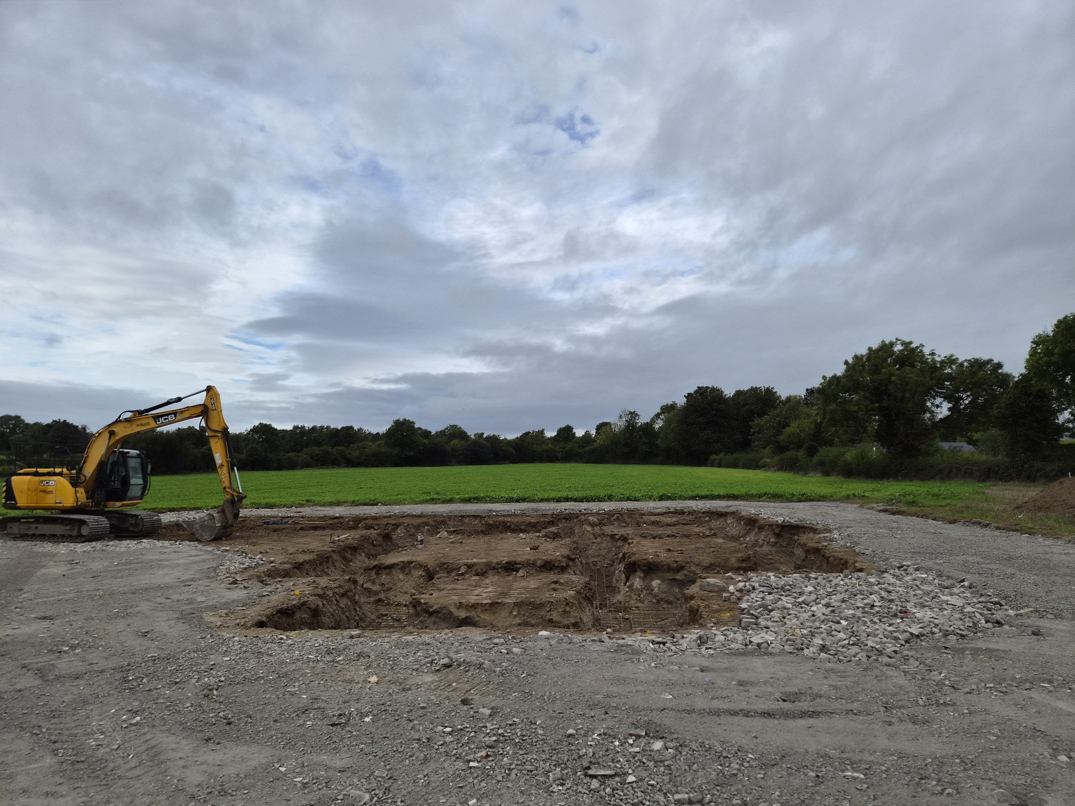 Excavator beside a prepared site