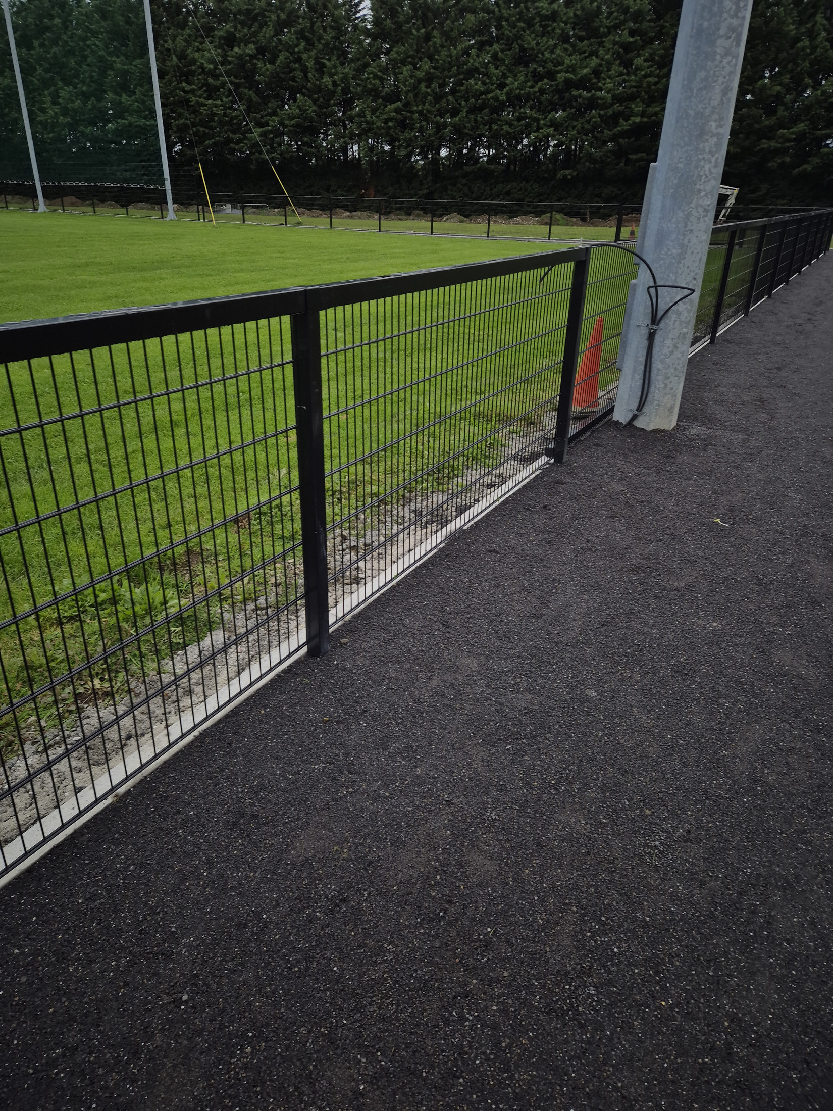 Asphalt path beside the pitch gate