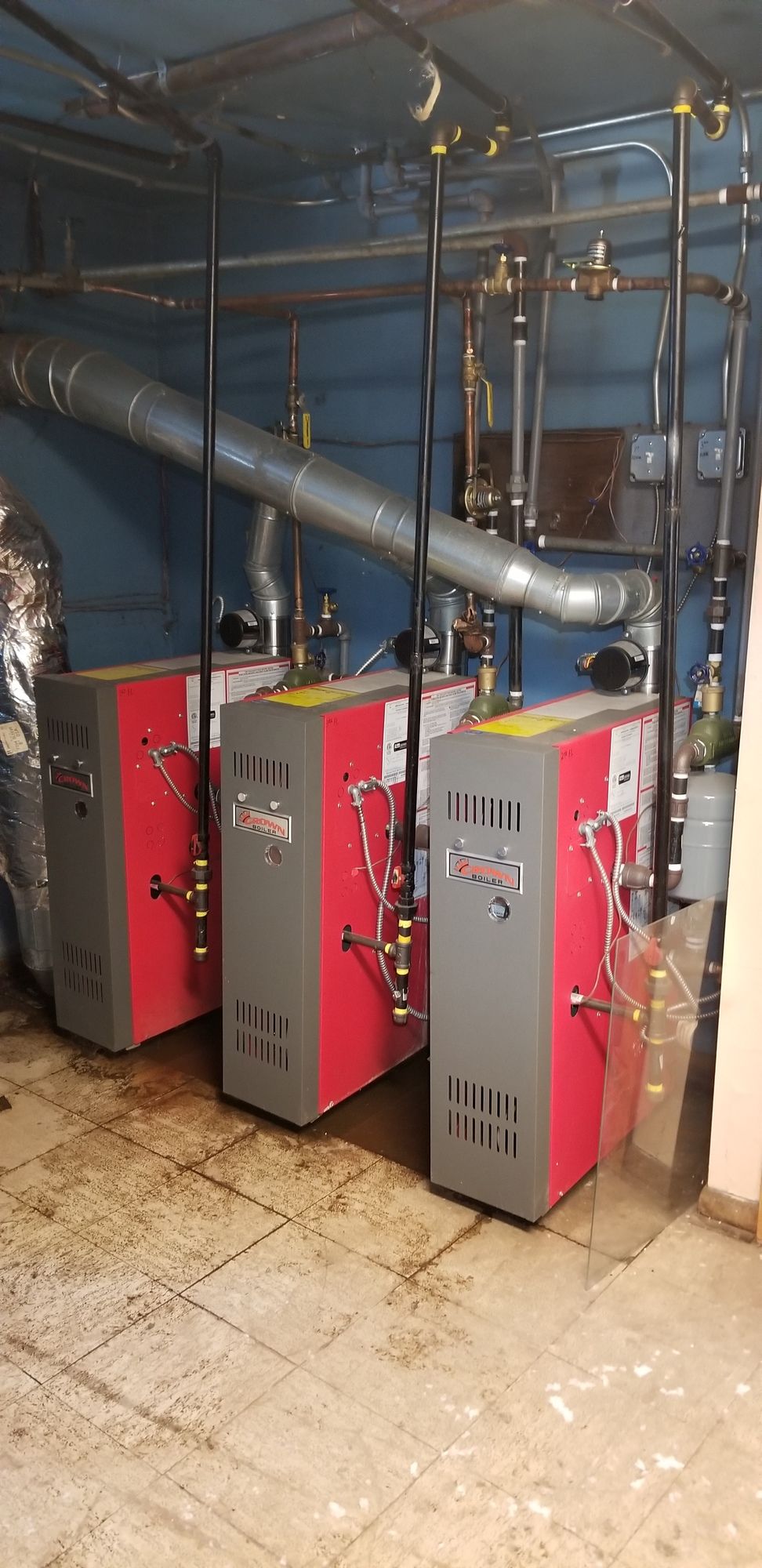 Three commercial heating units installed in a mechanical room