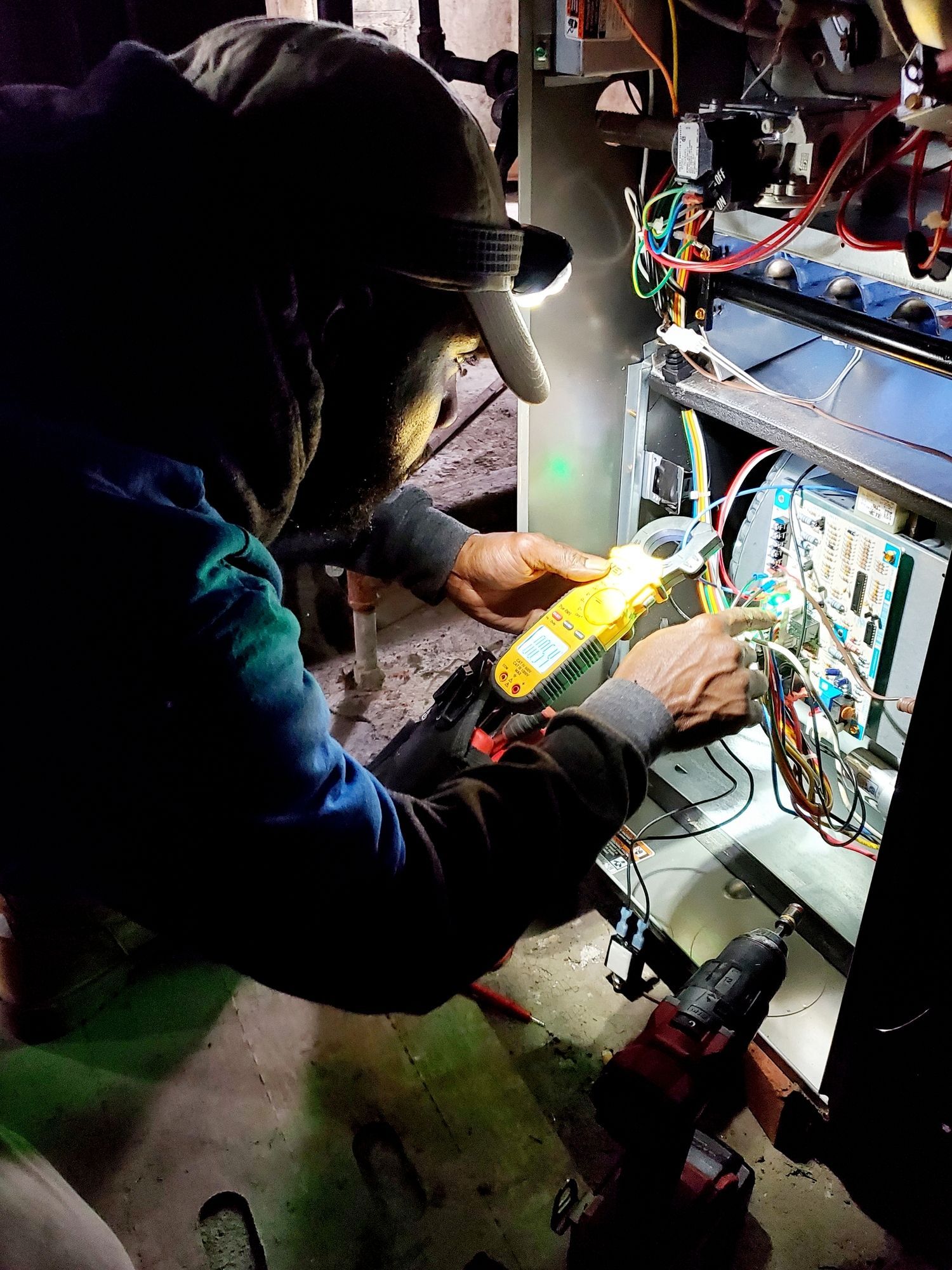 Gloved technician testing electrical controls inside HVAC equipment