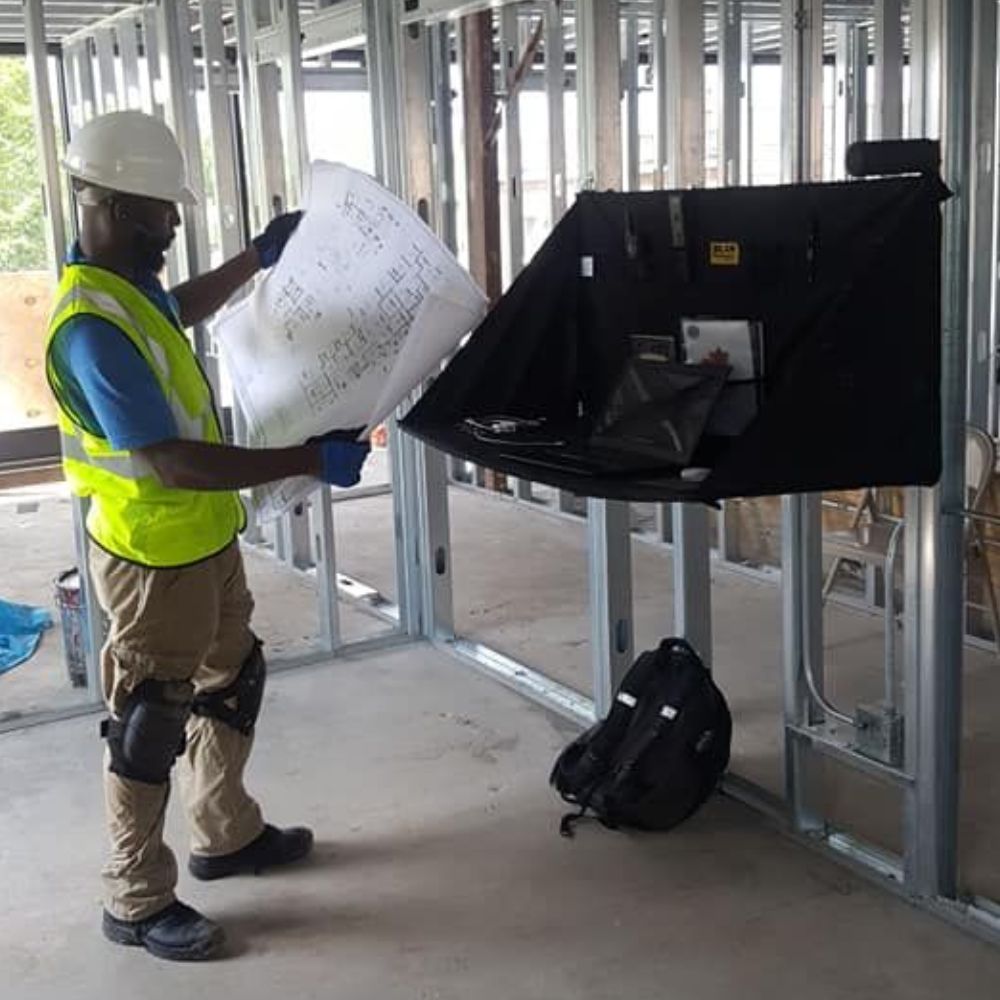 Technician reviewing plans during an active building renovation