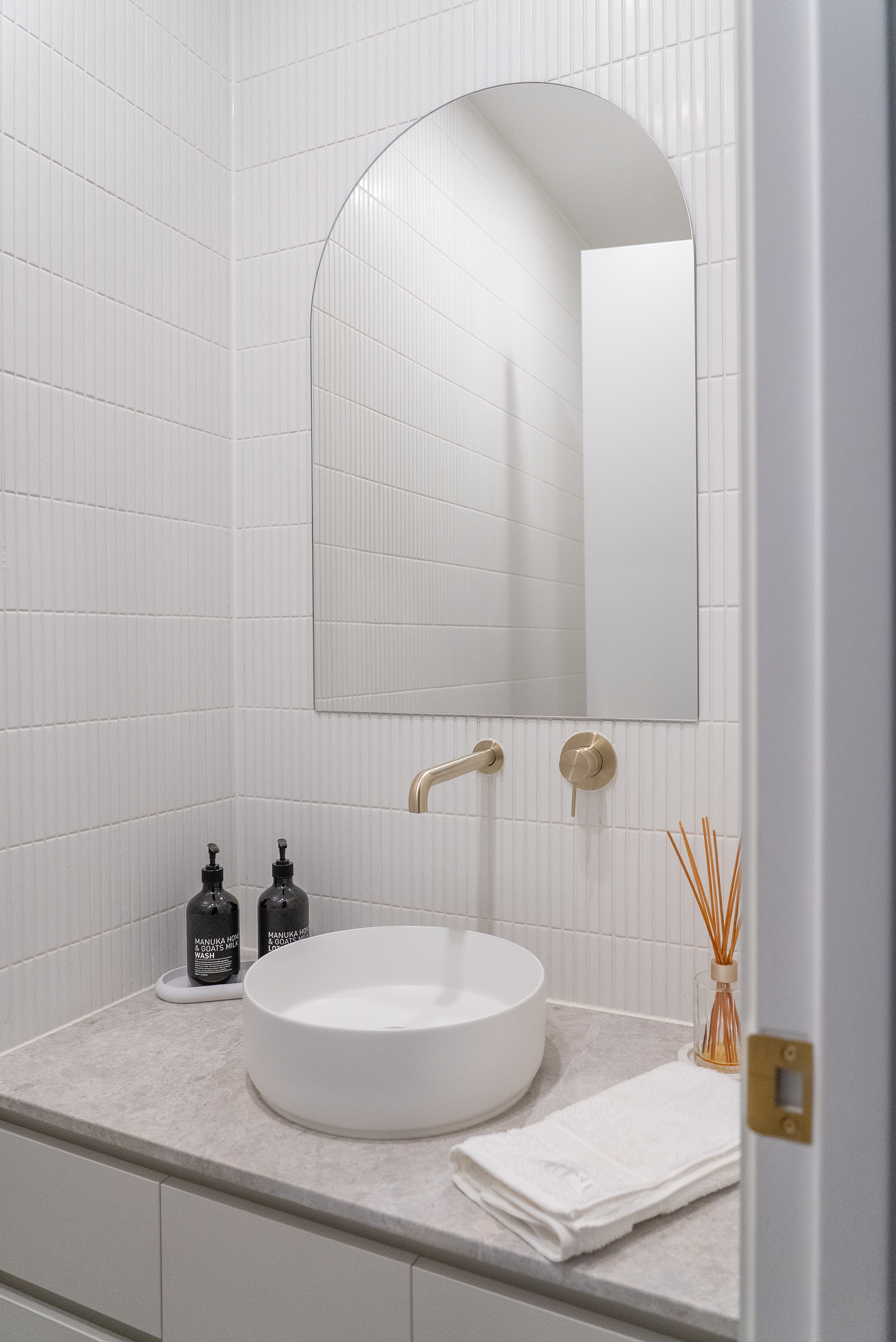 Bathroom renovation Melbourne with brass fixtures and modern basin design