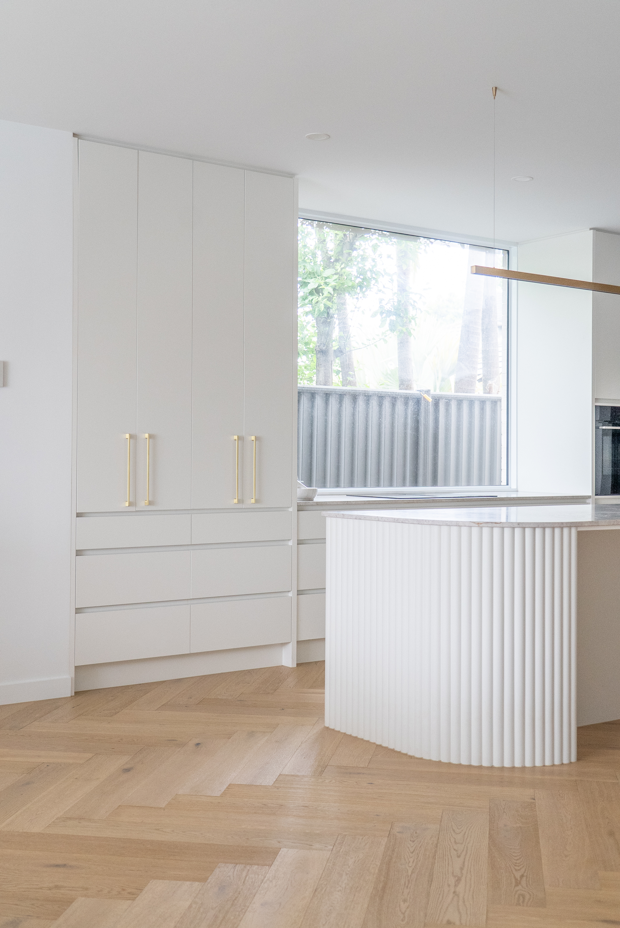 Kitchen renovation Melbourne with fluted island, modern cabinetry, and natural light design