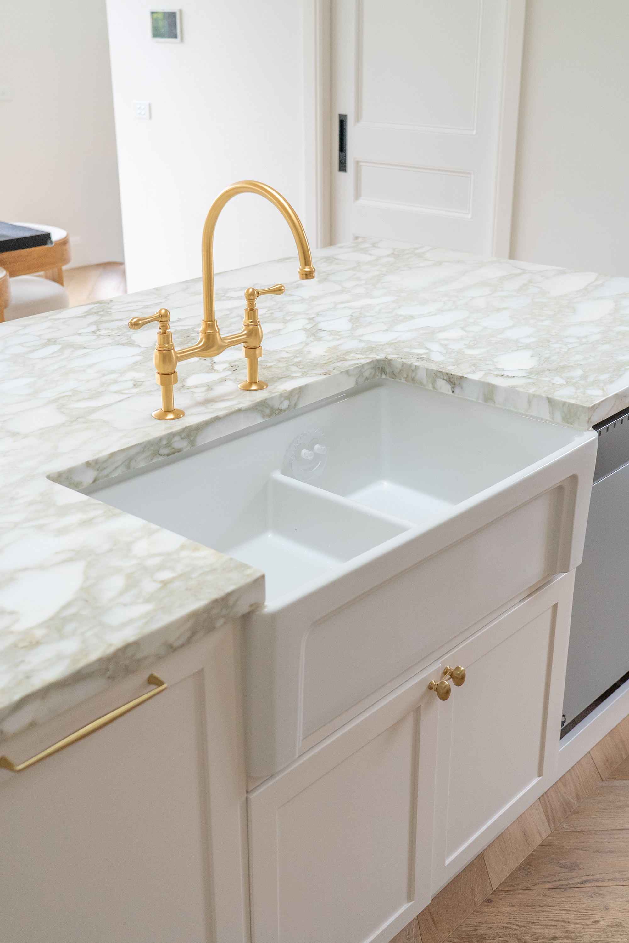 Kitchen renovation Melbourne farmhouse sink with marble benchtop and brass tapware detail