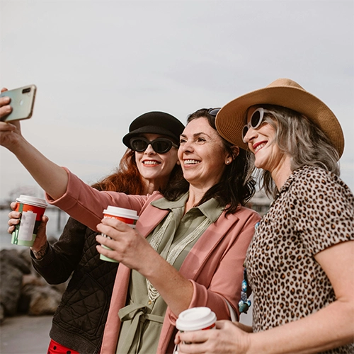 Group of midlife women laughing together outdoors, reflecting confidence, connection, and feeling comfortable in their bodies again