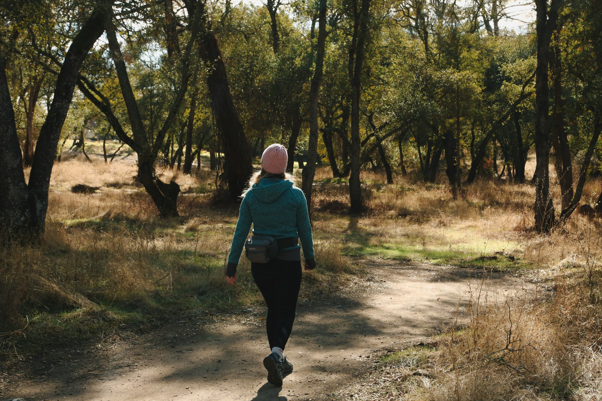 Midlife woman walking outdoors in nature, representing gentle movement and stress reduction for gut health in perimenopause