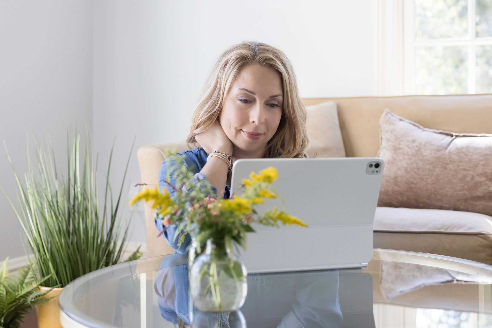 Midlife woman reviewing health information on a tablet in a bright, comfortable home setting.