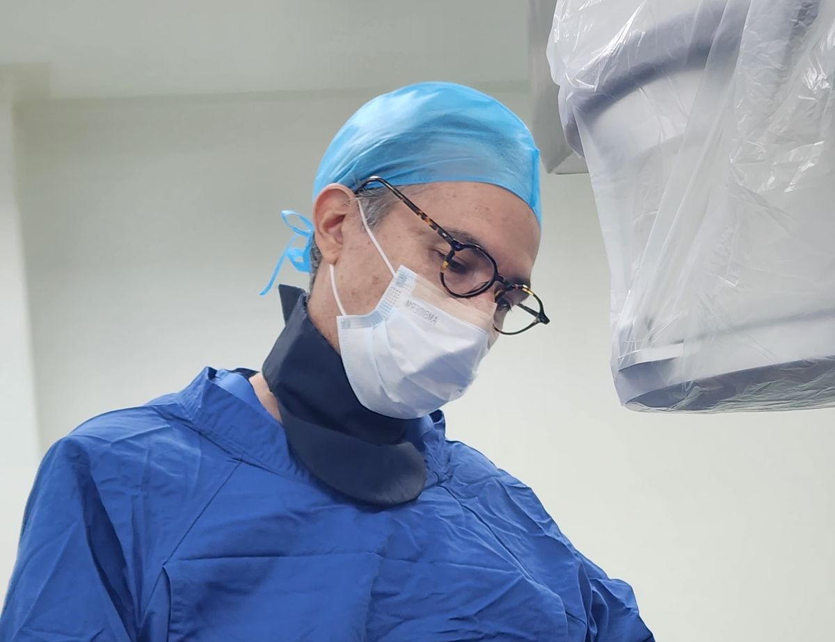 Dr. Eduardo Espinosa concentrado durante la atención médica de un paciente