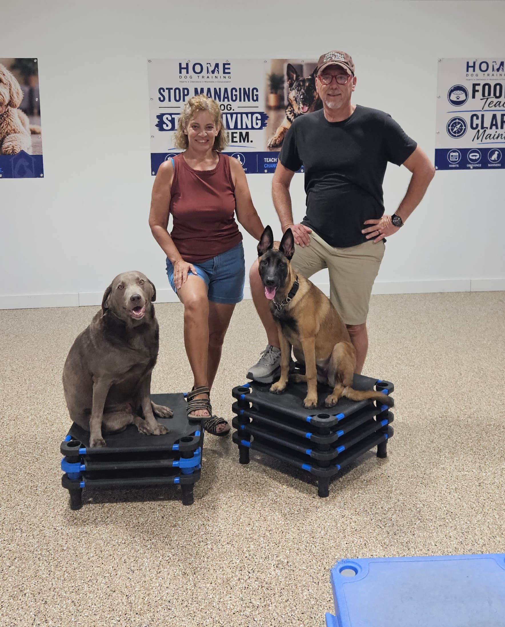 Charles and Laura Countryman, the two trainers behind HOME Dog Training, standing together with a dog