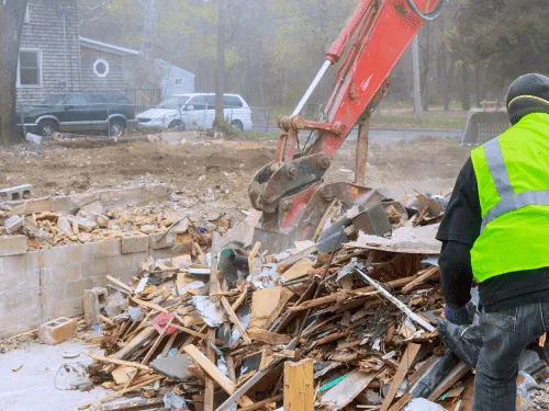 Junk Dads Junk Removal using heavy machinery to clear construction debris and wood from a residential site in Alpharetta GA.