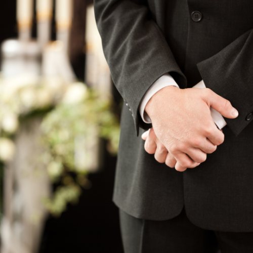 Clasped hands of a funeral director. We can assist with funerals.r