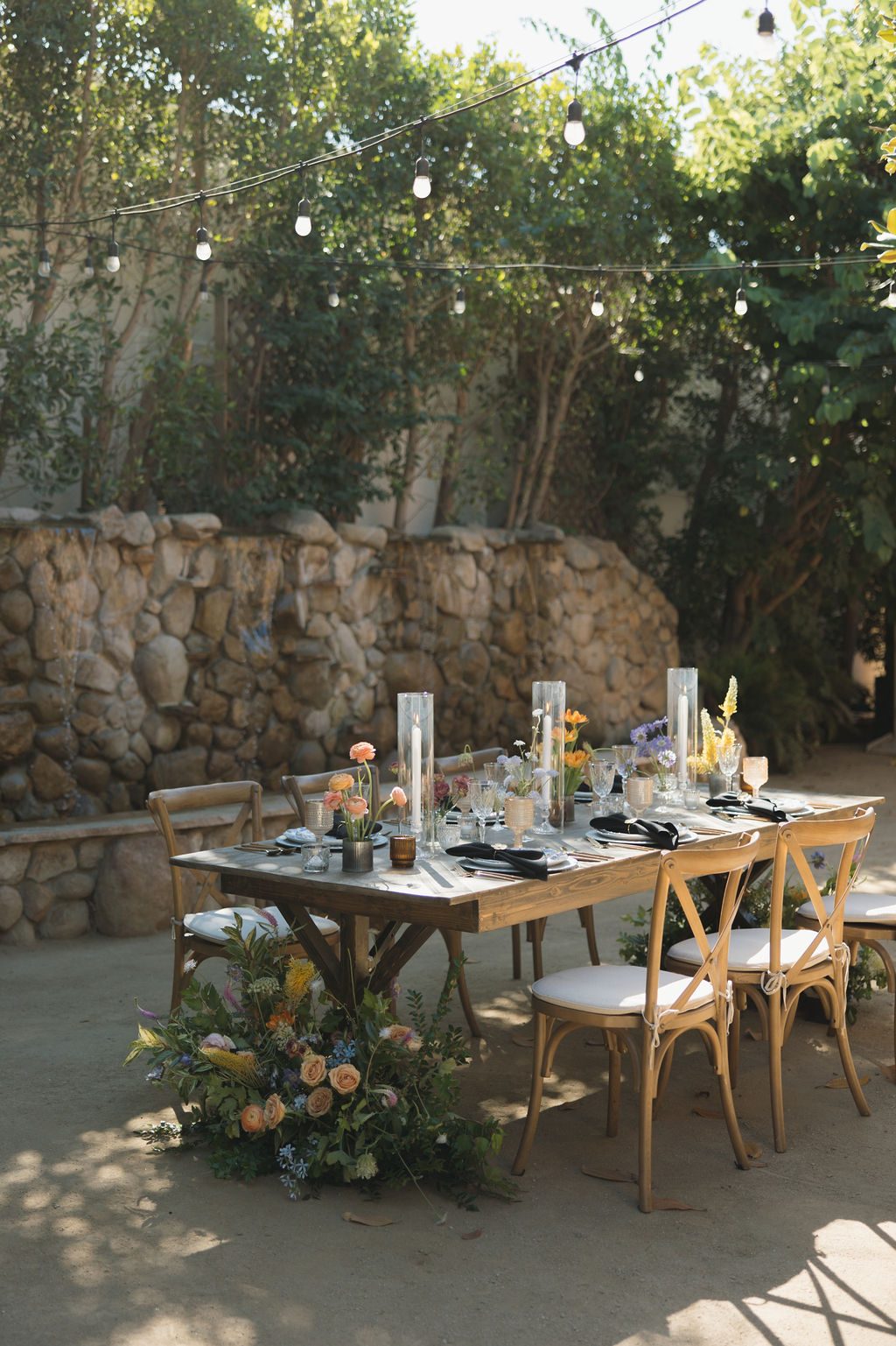 A table set in the courtyard under bistro lights