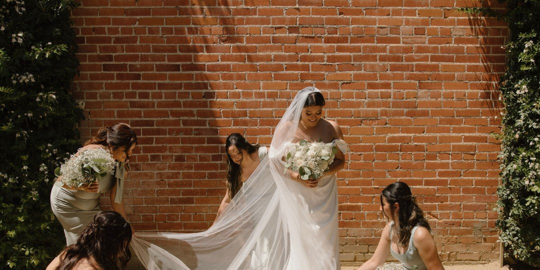 Bride and bridesmaids against the brick wall