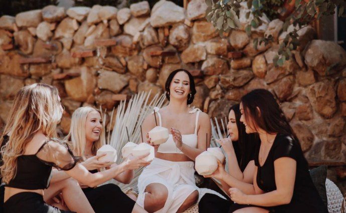 Bridal party laughing by the stone wall