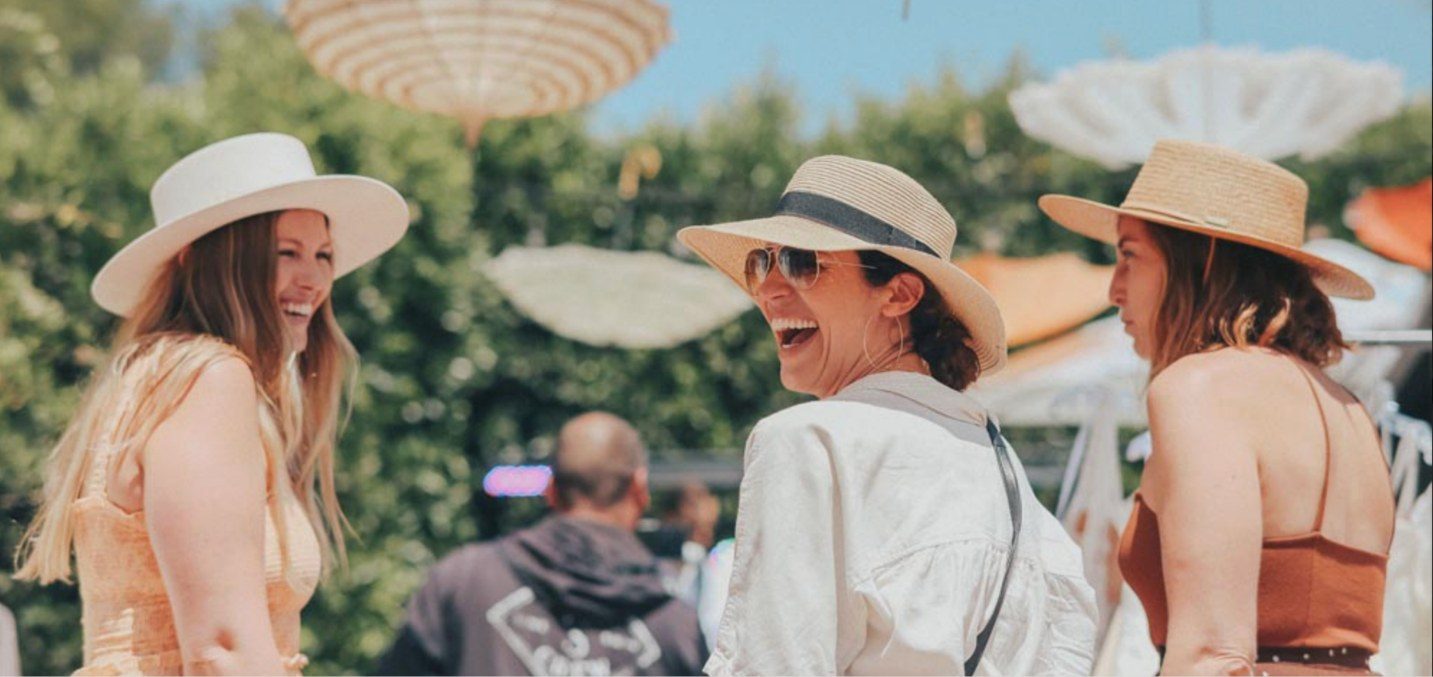 Guests in sun hats laughing at a party