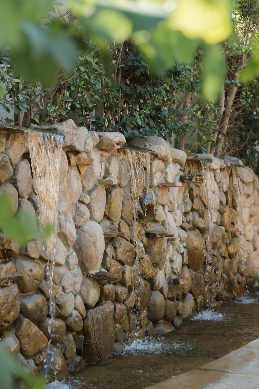 Water spilling over the hand-laid stone wall